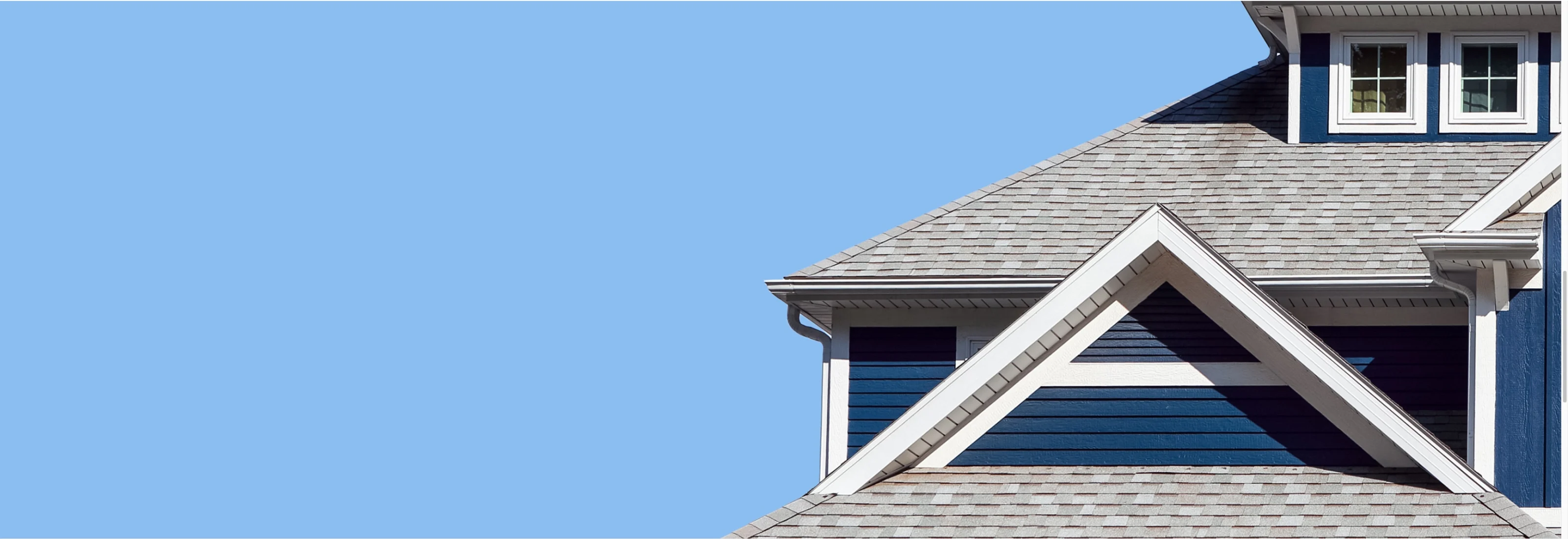Navy home with gabled roof against a blue sky