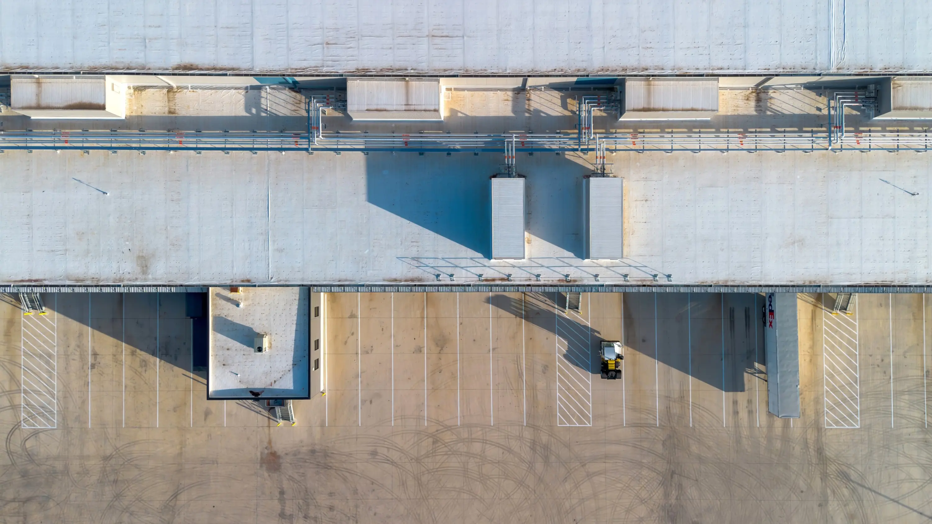 Aerial view of a long commercial roof edge with rooftop units