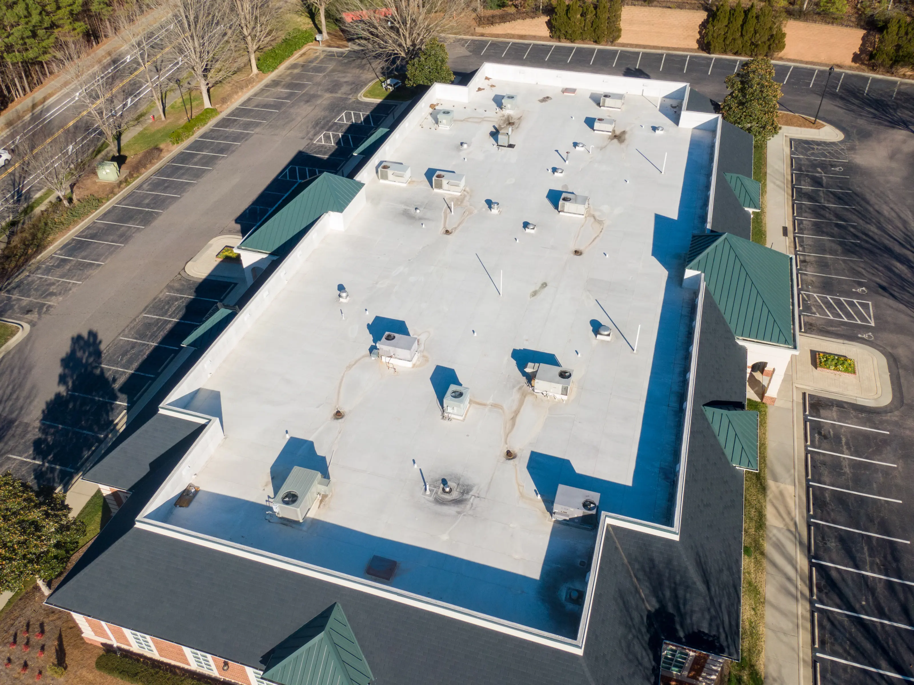 Aerial view of a large flat commercial roof with rooftop HVAC units