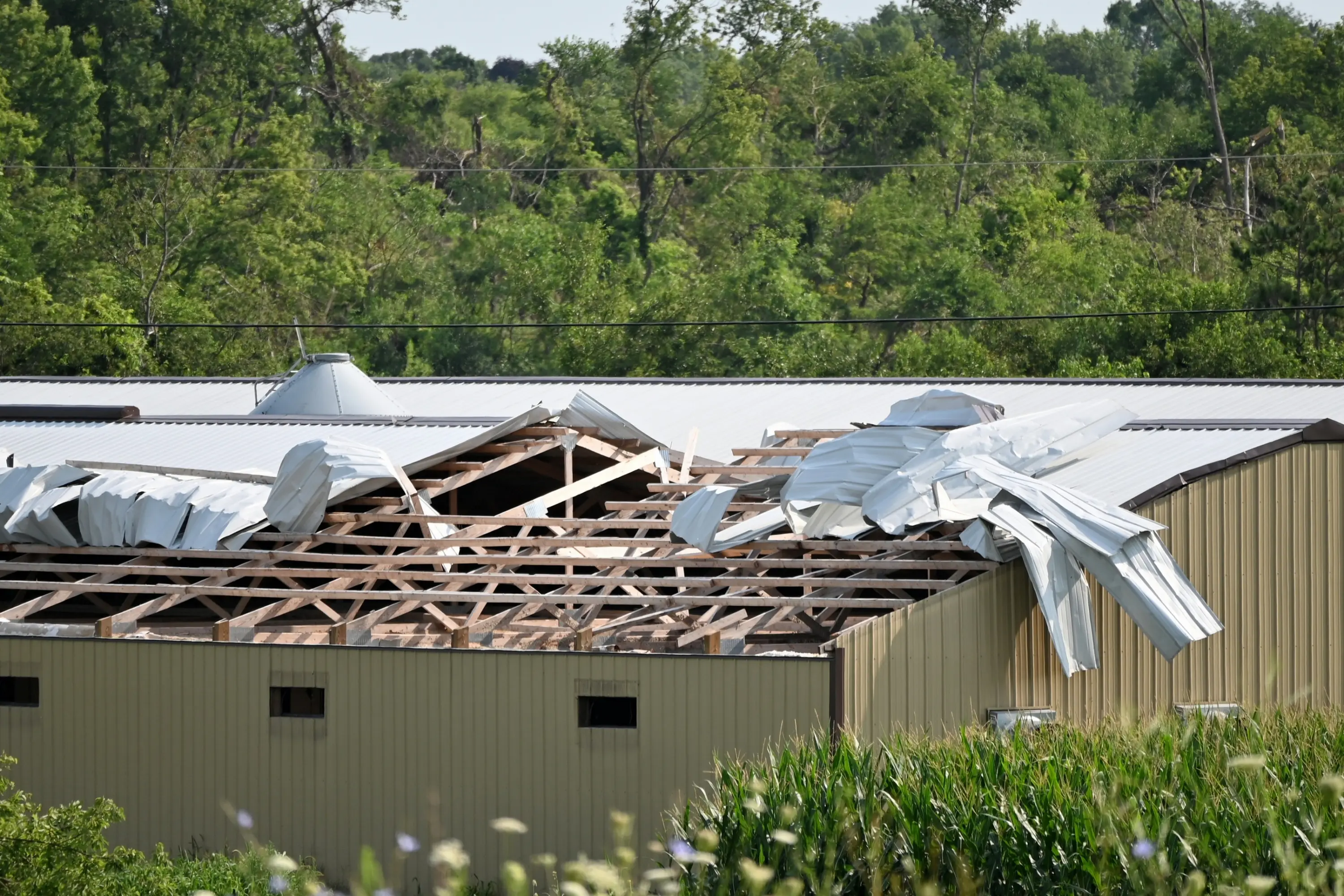 Metal commercial building with its roof torn open by a storm
