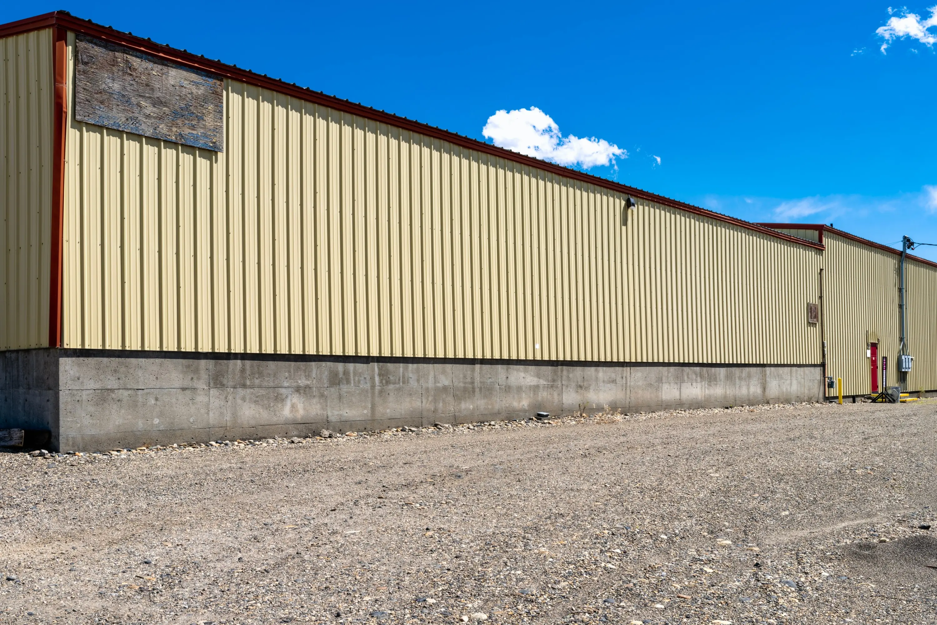 Weathered metal siding on a long commercial warehouse