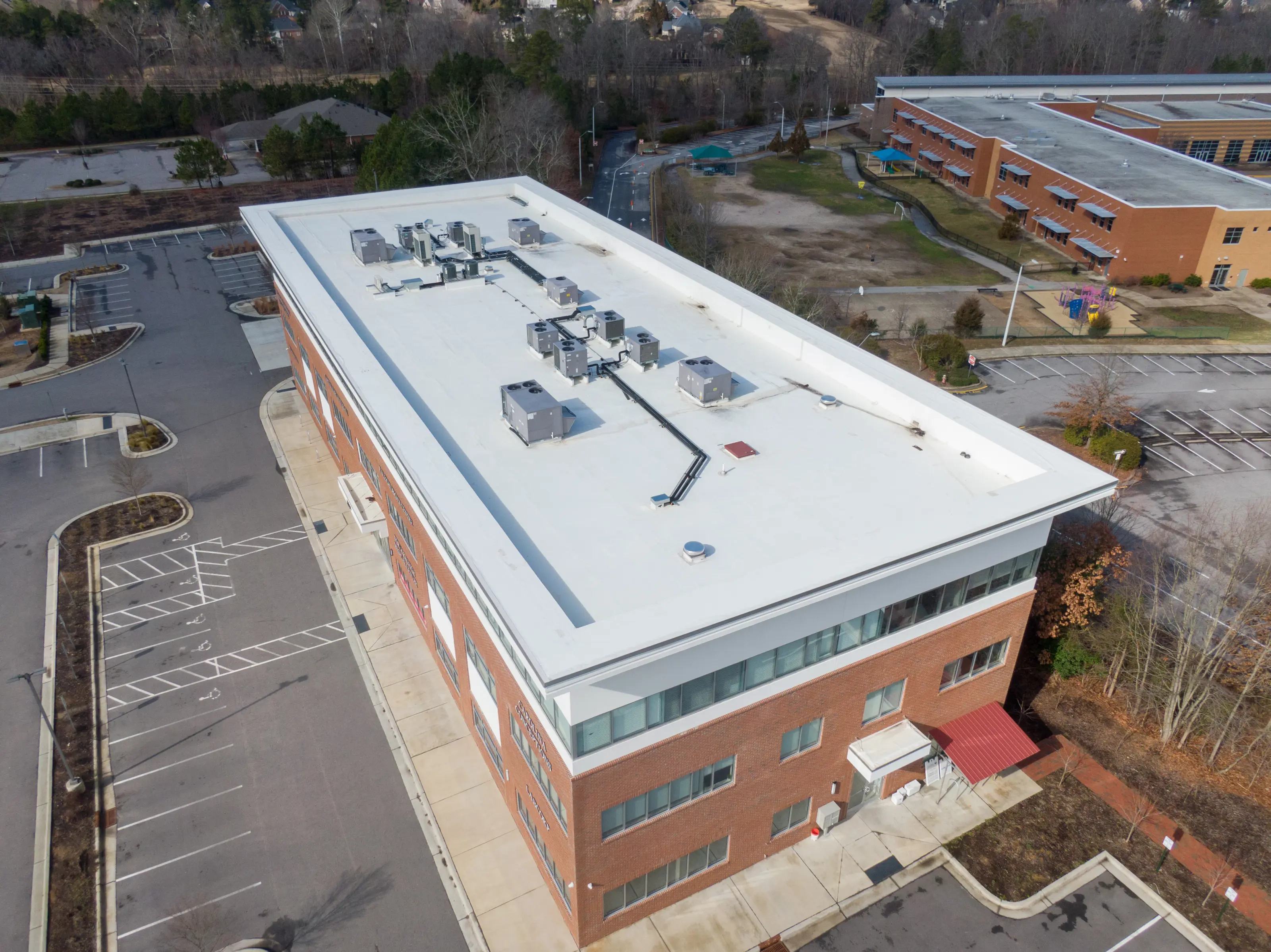 Brick office building with a white flat roof, seen from above