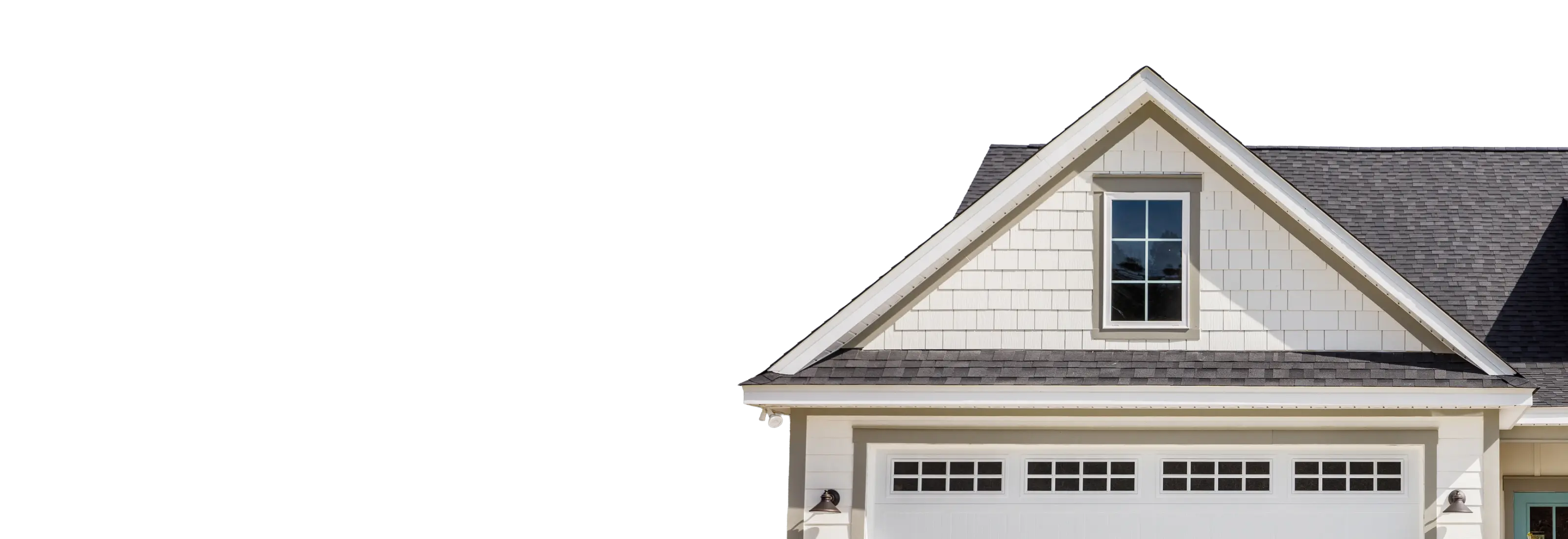 White house gable above a double garage door against a blue sky
