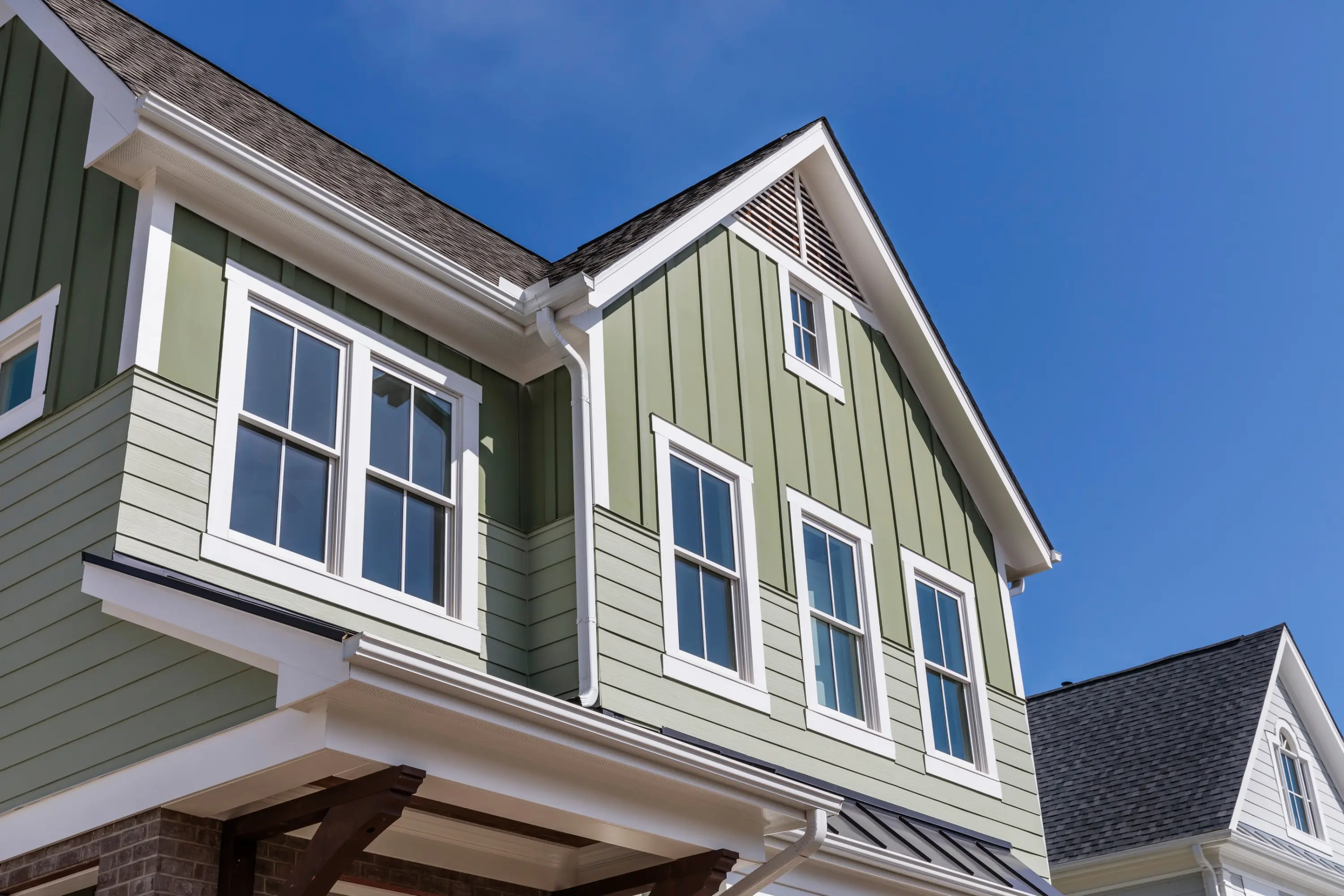 Green board-and-batten siding on a two-storey home